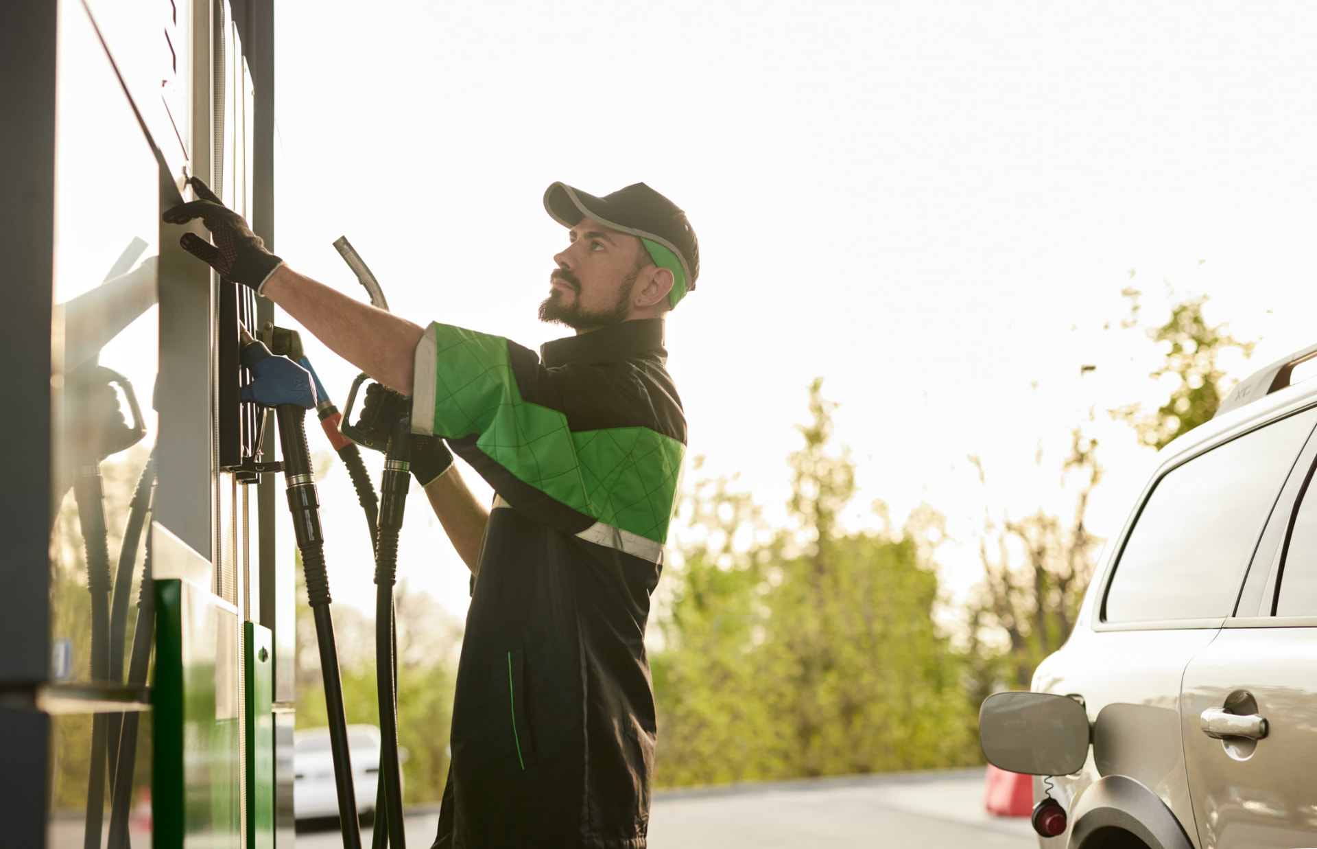 Fuel attendant handling pump nozzles at a station