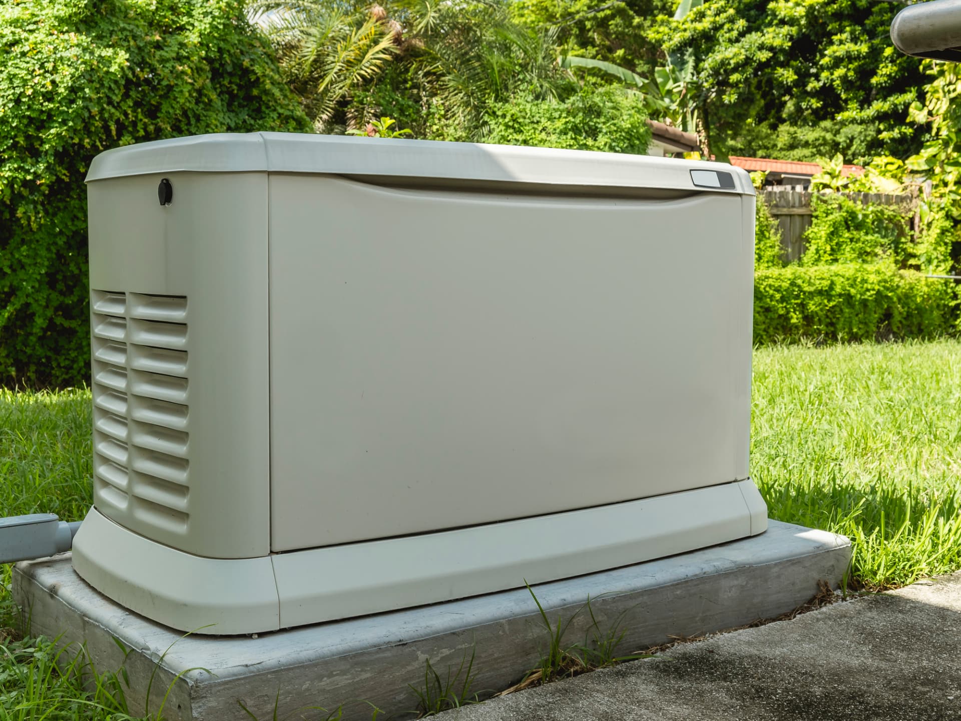 Standby generator in a Gulf Coast yard surrounded by greenery