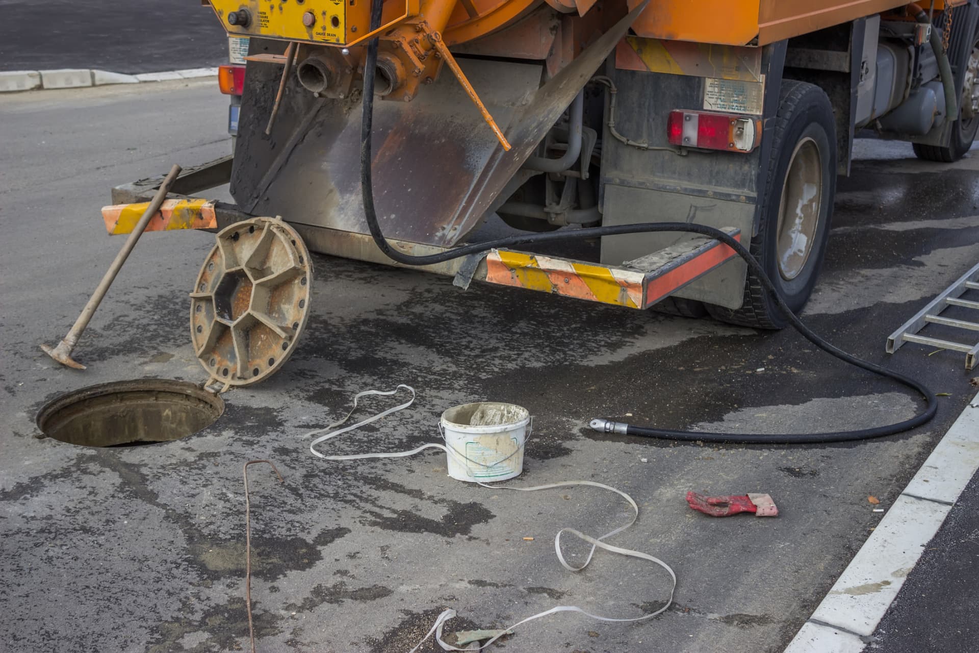 Pump truck hose running into an open tank access hole