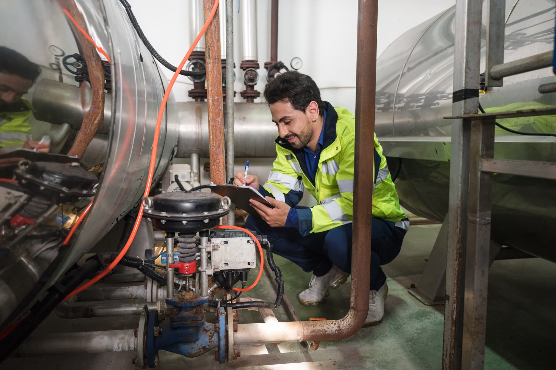 Technician documenting valves on a fuel storage tank